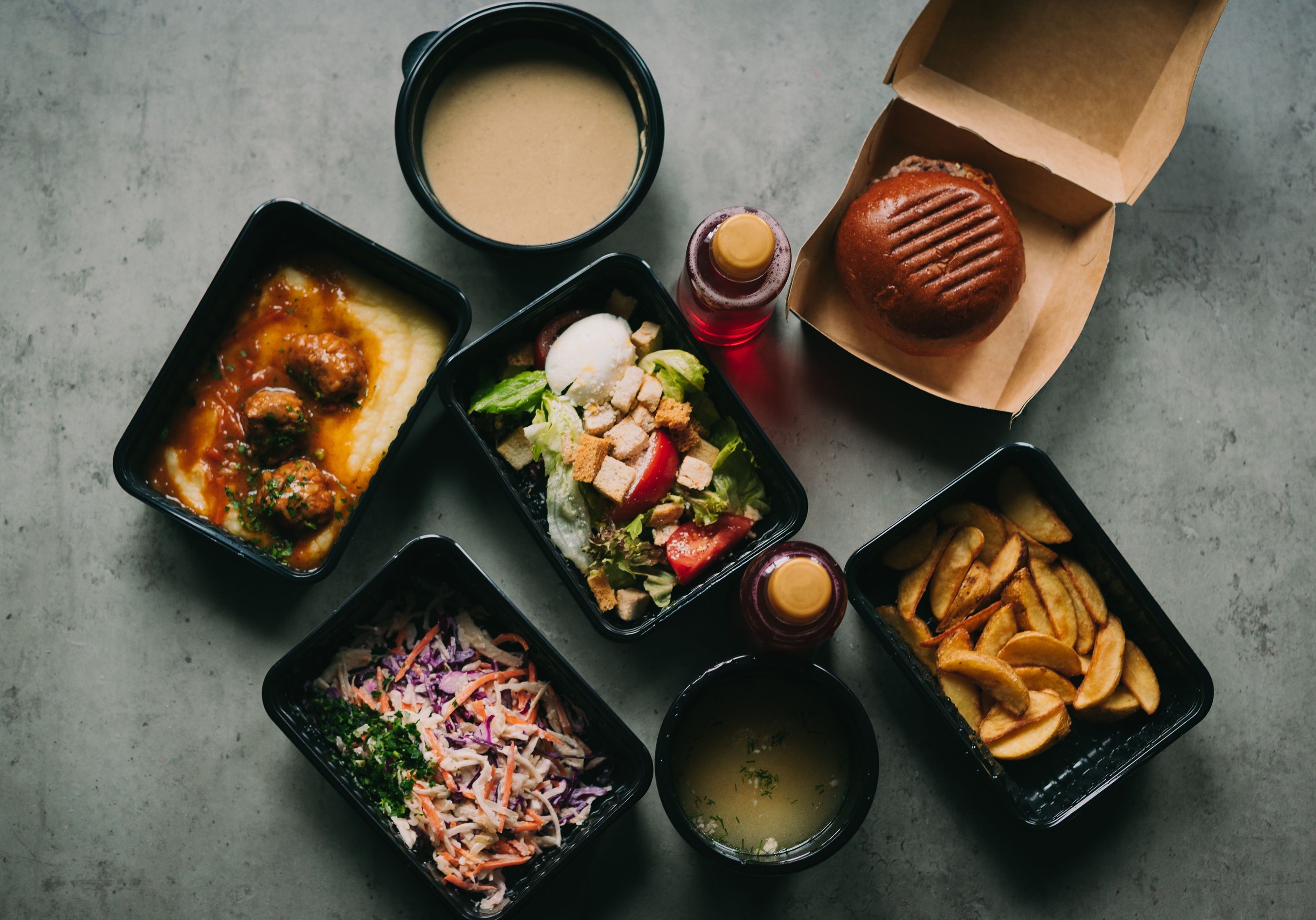Manos guardando platos de comida para llevar en la nevera, mostrando envases bien cerrados y etiquetados para su correcta conservación